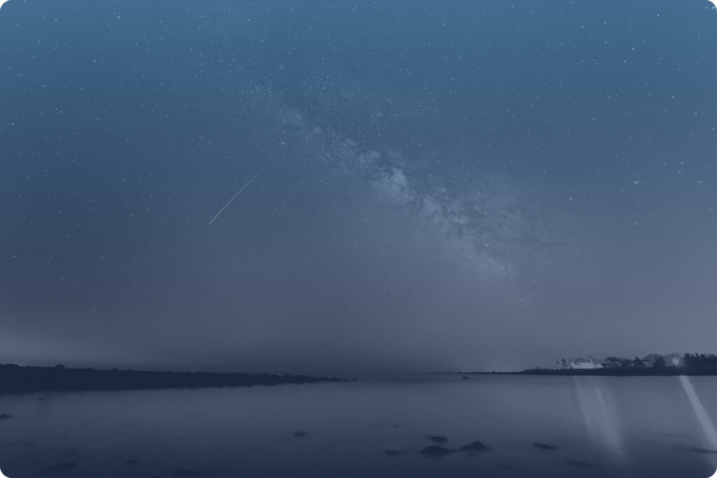 Foto eines Sternenhimmels bei Nacht mit Sternschnuppe